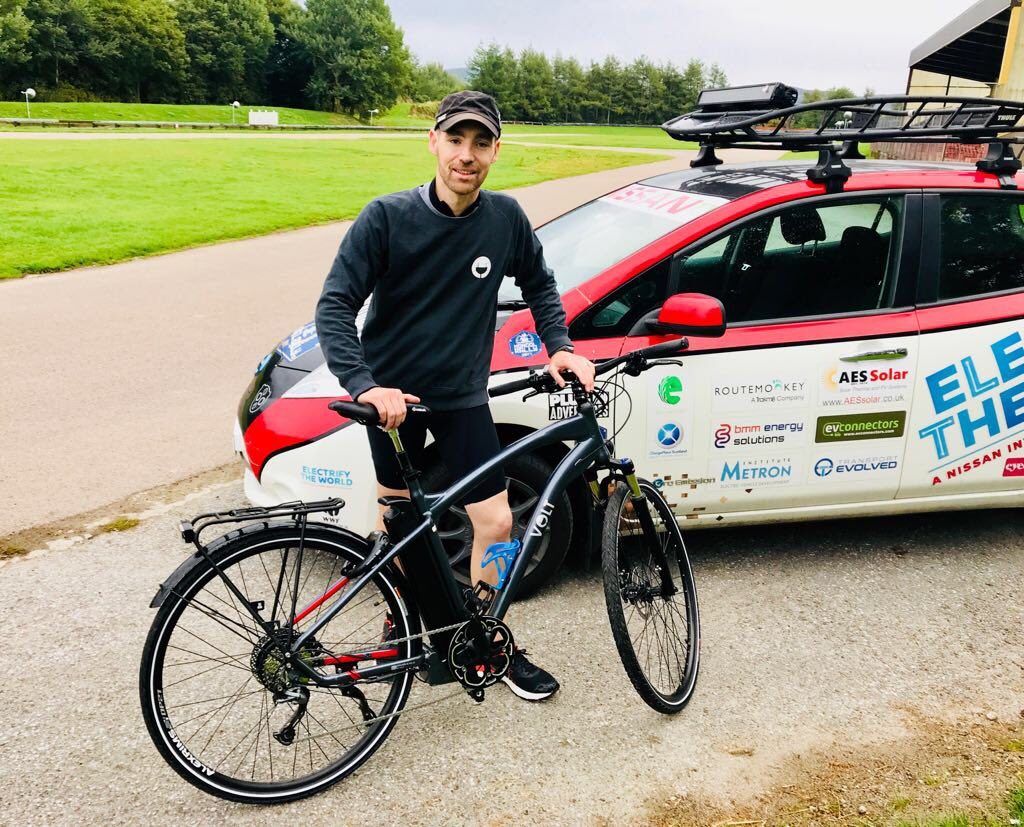 Chris Ramsey from Plug In Adventures poses next to the VOLT Pulse e-bike